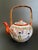This antique Kutani eggshell porcelain tea set includes a teapot and a matching teacup trio, featuring hand painted geisha...
