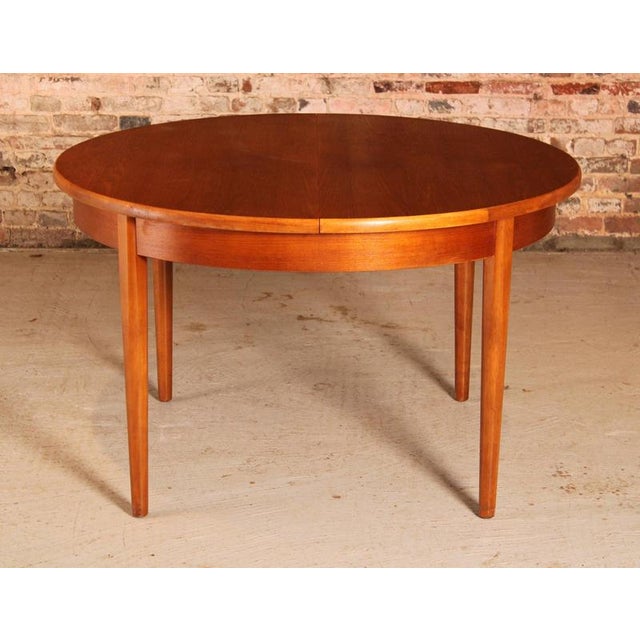 Mid Century round extending teak dining table by Jentique, circa 1960s. Butterfly extension leaf stored underneath....