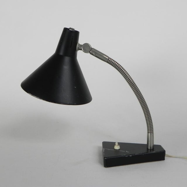 This model with the black shade is adjustable thanks to a flexible arm and an adjustable shade. the paint on the hood is...