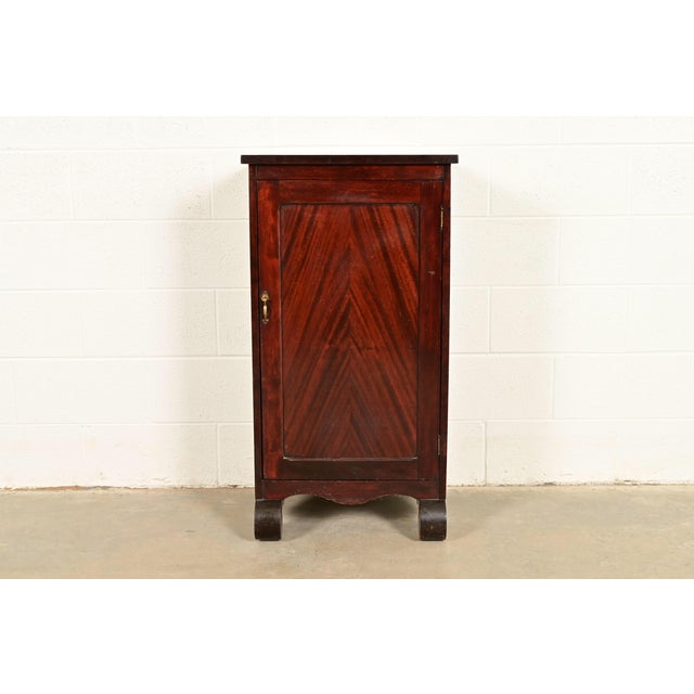 A beautiful antique American Empire or Victorian style music cabinet or bar cabinet USA, Circa 1890s Carved mahogany, with...