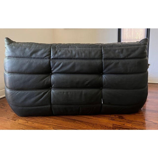 An authentic vintage Togo designed by Michel Ducaroy for Ligne Roset in 1973. Upholstered in its original black leather,...