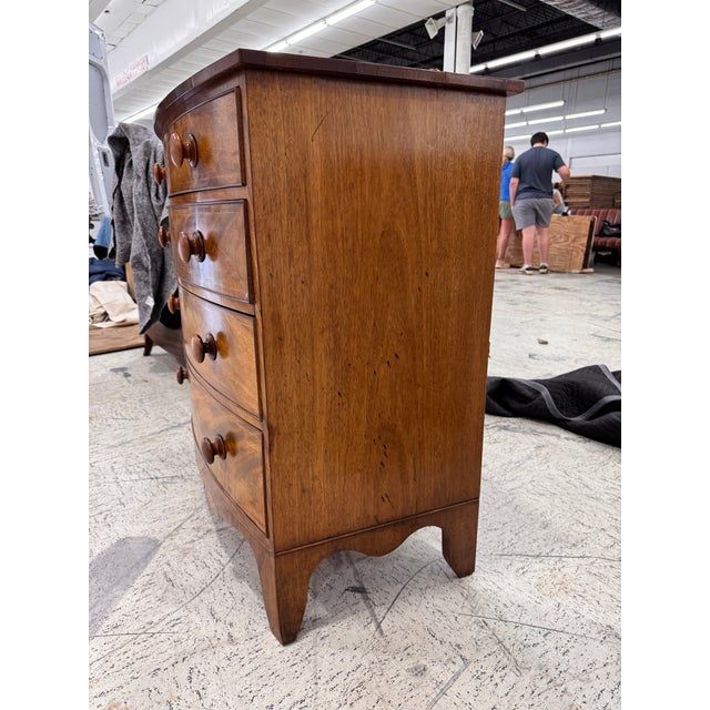 This 19th century English Bow Front Chest of Drawers is a beautifully designed piece of furniture, featuring tastefully...
