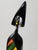 This whimsical wood sculpture of a person features a black lacquer base with vibrant colors added to the chest area of the...