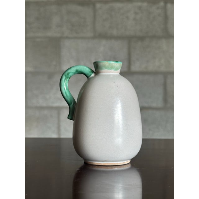 Small off white vase with a green handle from Sweden circa 1940s. Really nice form and glaze.