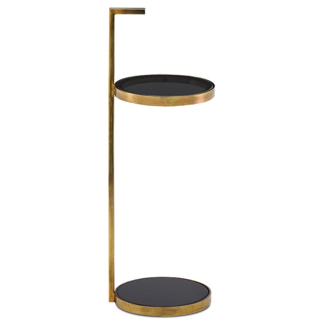 Our Silas Drinks Table is made of steel in a brass antique finish with circular panes of smoke glass. The black and gold...