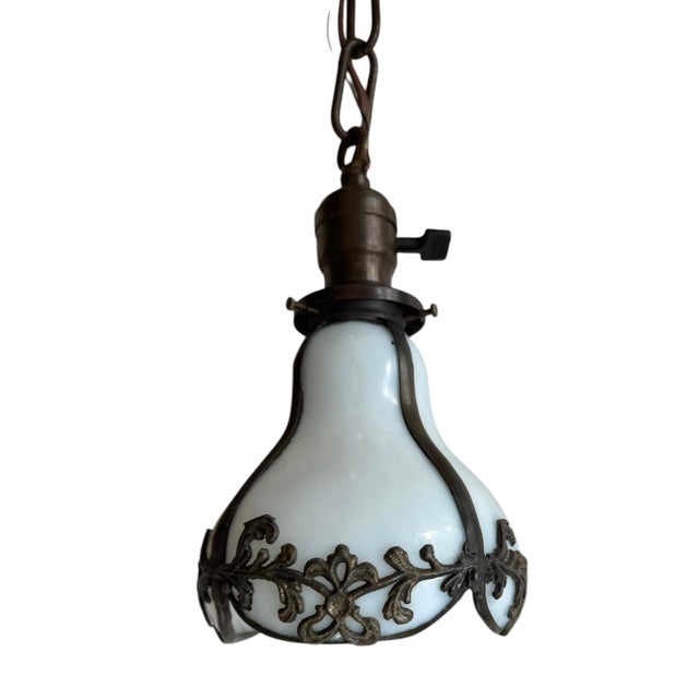Rare Antique hanging pendant light featuring a pear-shaped white opalescent glass shade held in an ornate bronze-toned...