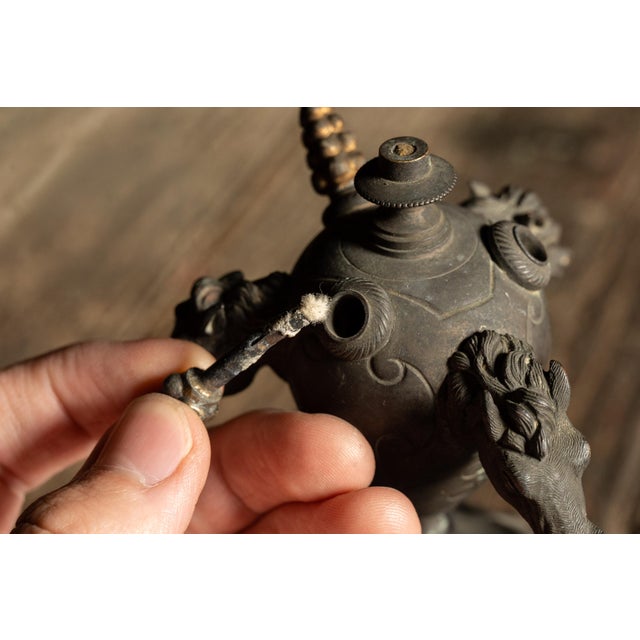 Figural kerosene cigar lighter and smoking stand with horse-head finials. This ornate Victorian-era smoking accessory...