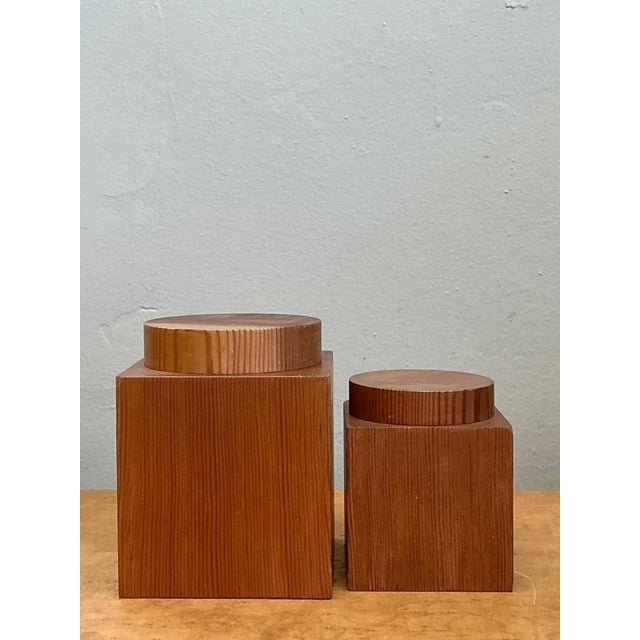 This refined set of two vintage square wood storage boxes reflects the timeless appeal of minimalist mid-century design....