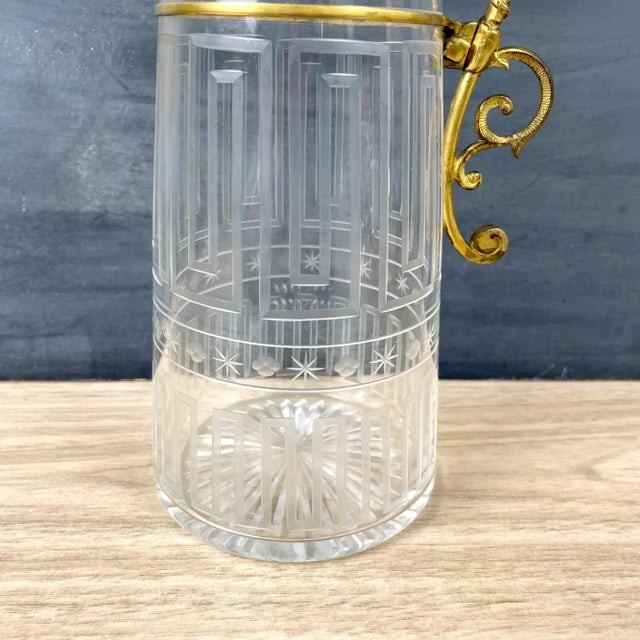 Cut glass claret jug with the Greek key pattern around body and a beautiful fancy gold tone metal collar and handle....