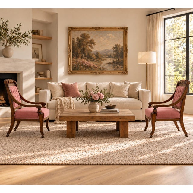 Elegant pair of Empire-style walnut armchairs featuring gracefully curved arms, carved turned arms supports, and rolled...