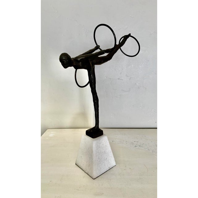 Beautiful bronze sculpture of an acrobat performing with three hoops. The sculpture stands 10” high and 17” wide including...