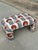 A charming vintage upholstered bench newly reupholstered in striking designer embroidered fabric featuring bold coral-red...