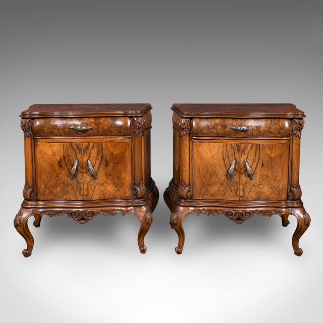 This is a pair of vintage bedside cabinets. An Italian, burr walnut bedroom nightstand in Rococo taste, dating to the late...