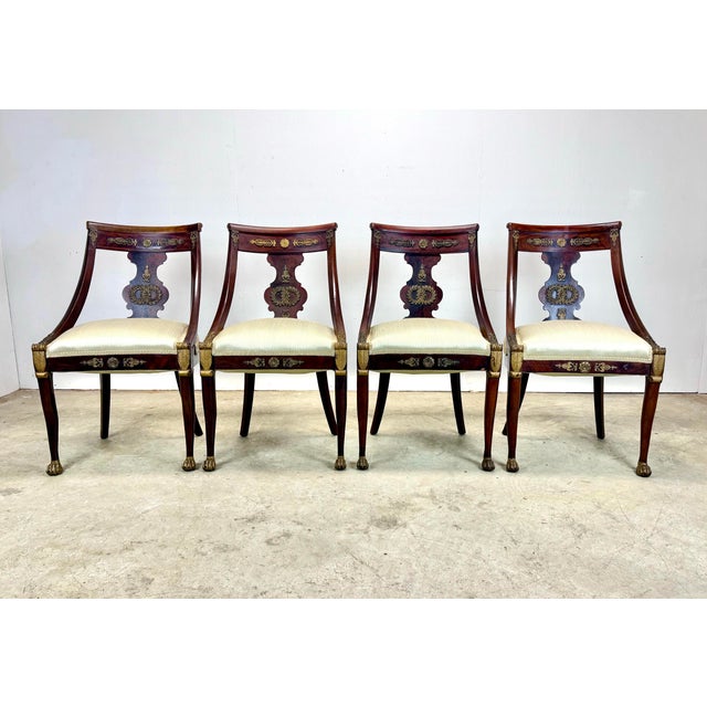 An exquisite set of 4 French Empire / Directoire side chairs with bronze ormolu mounts, mahogany frames with gilt...