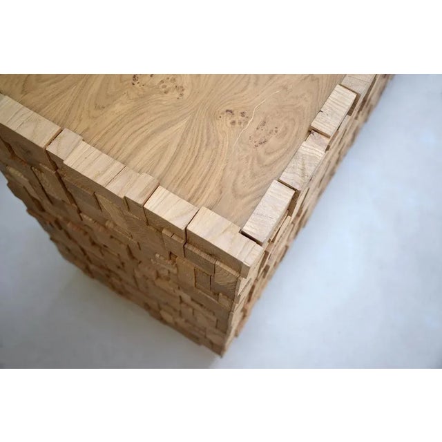 "CAOS is covered entirely with small oak solids, which create an interplay of reliefs on the entire outer surface of the...