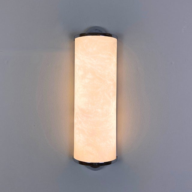 Vintage wall sconce crafted from natural alabaster and chrome-plated metal, featuring a refined semi-cylindrical design....