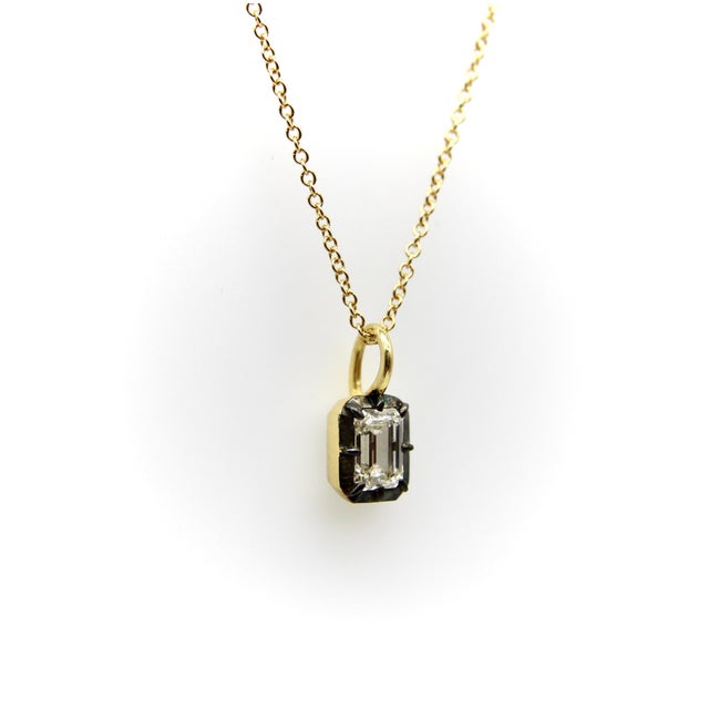 This 18k gold necklace holds a beautiful Emerald Cut half-carat diamond in a collet setting. One of the oldest gemstone...