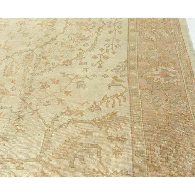 This exquisite antique Turkish Oushak rug from the early 1900s is a superb example of Anatolian craftsmanship, known for...