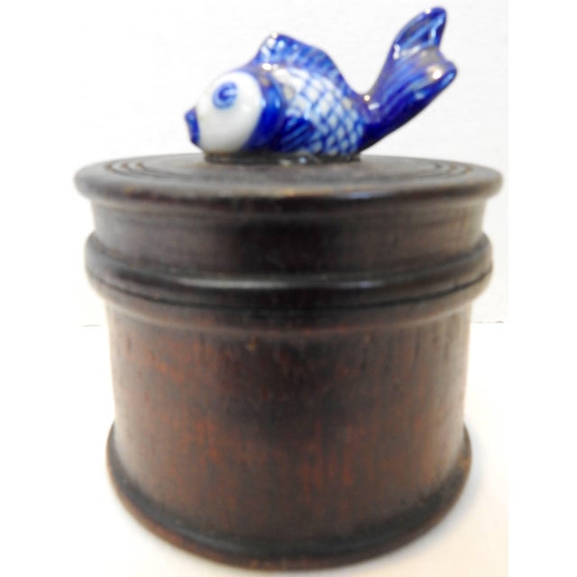 A hand-painted porcelain koi fish is perched on top of the lid of this round wooden box. The lid comes off for you to...