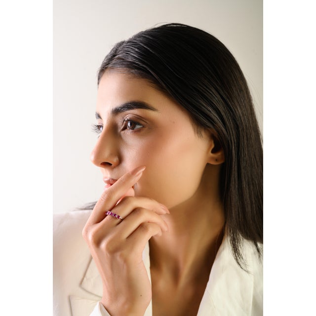 This elegant eternity band showcases five square step-cut red rubies totaling 0.71 carats, set in 14k white gold. Each...