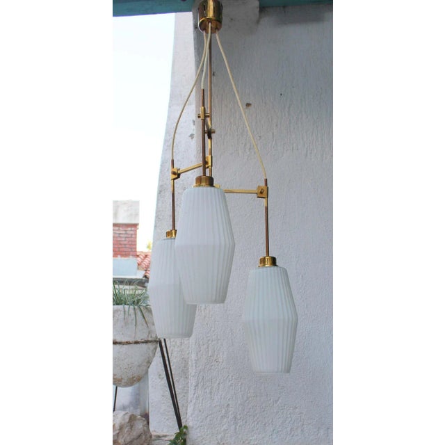 Italian brass chandelier 1940 s .Brass and white ribbed glass, one of the glass shade has a little chip circa 1/16 of the...