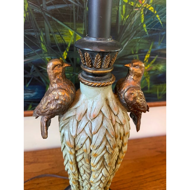 Sculptural vintage table lamp featuring a richly detailed feathered form accented with two perched birds. The lamp rests...