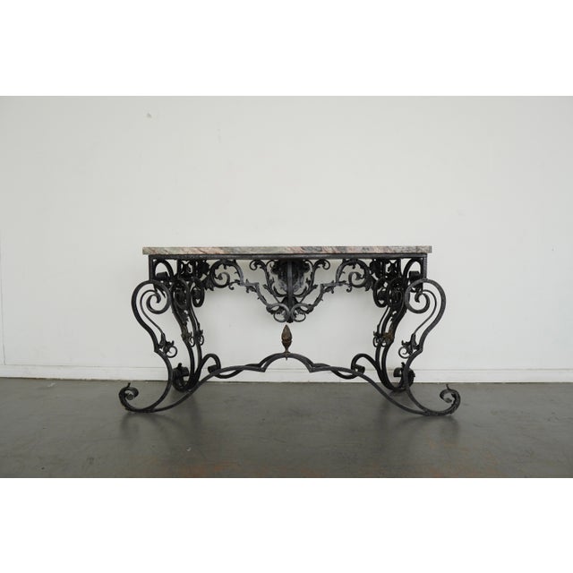 Atributed to Maitland-Smith console table features an elaborately sculpted metal base with scrolling forms, acanthus leaf...