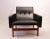 This , model 65 23 easy chair, with model 64 23 stool, is upholstered in black classic leather with a frame in teak. The...