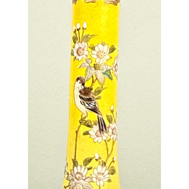 This antique Meiji period (c.1890's) Japanese ceramic vase features a bright yellow ground decorated with white blossoming...