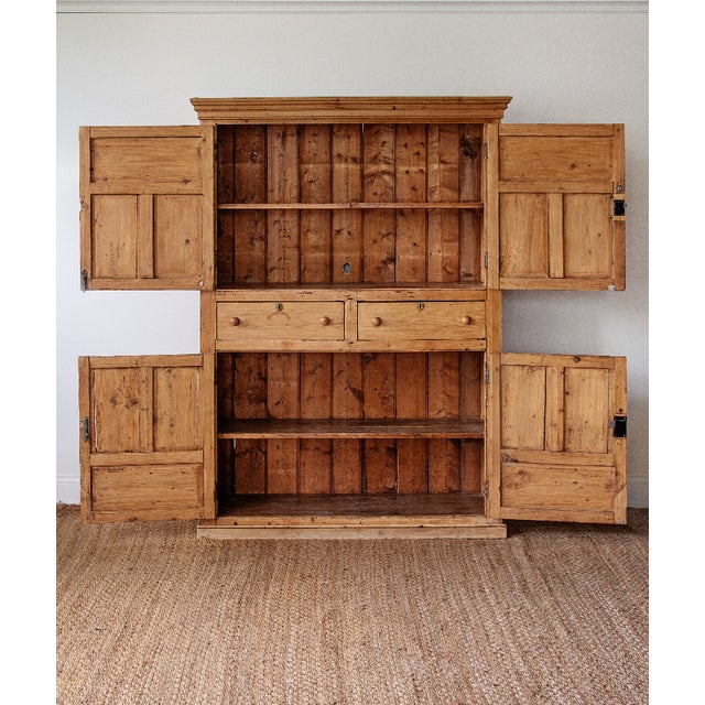 A beautifully proportioned antique English pine cupboard crafted in solid pine with warm honey-toned patina and...