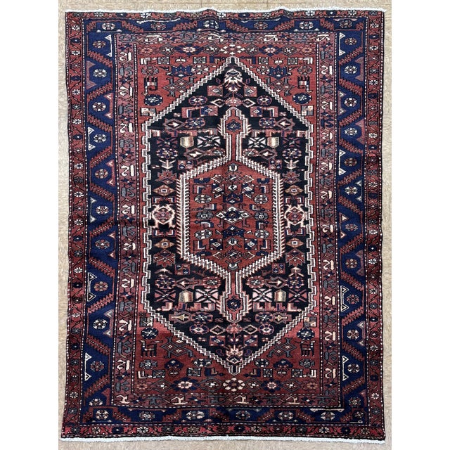 Antique hand-knotted rug from the Hamedan region of western Iran, featuring a bold central hexagonal medallion enclosed...