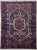 Antique hand-knotted rug from the Hamedan region of western Iran, featuring a bold central hexagonal medallion enclosed...