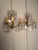 Pair of two-arm French wall sconces dating to circa 1890, crafted in bronze and crystal with elegant decorative detailing....