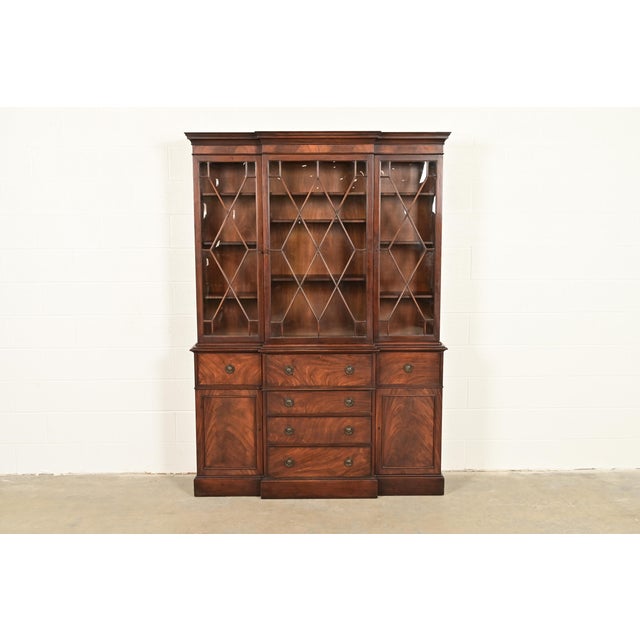 A beautiful Georgian or Chippendale style breakfront bookcase or dining cabinet with drop front secretary desk By Baker...