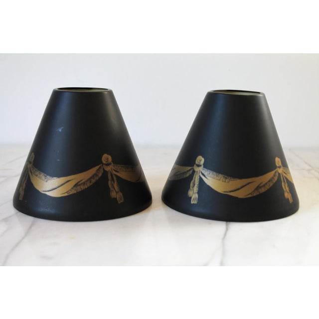 Pair of vintage tapered cone-shaped toleware metal lamp shades features a classic black finish accented with gold...