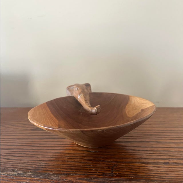 Made in Kenya. A charming mid-century hand-carved wooden catchall bowl featuring a sculptural elephant figure. Crafted...