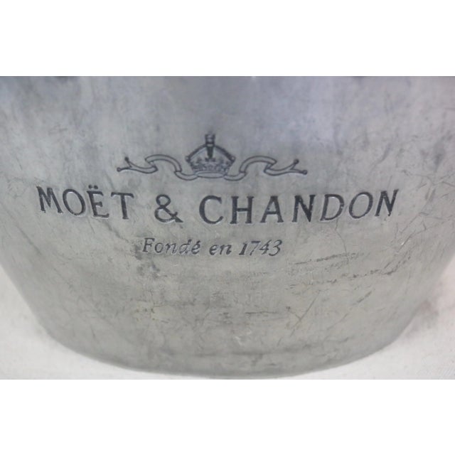 A mid 20th century pewter champagne bucket advertising the brand, "Moet & Chandon." Each side of the bucket had the name...