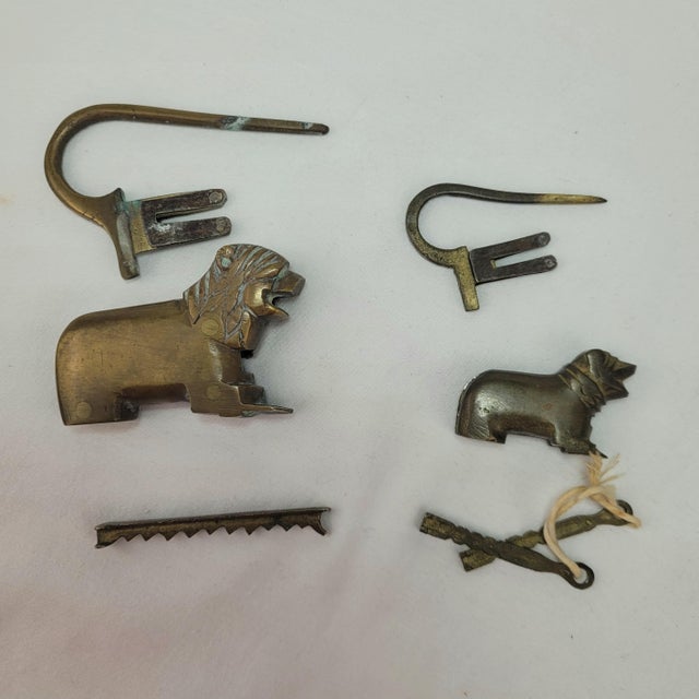 Antique-style brass padlocks featuring a lion and a dog or small lion cub, crafted with a traditional puzzle or trick...