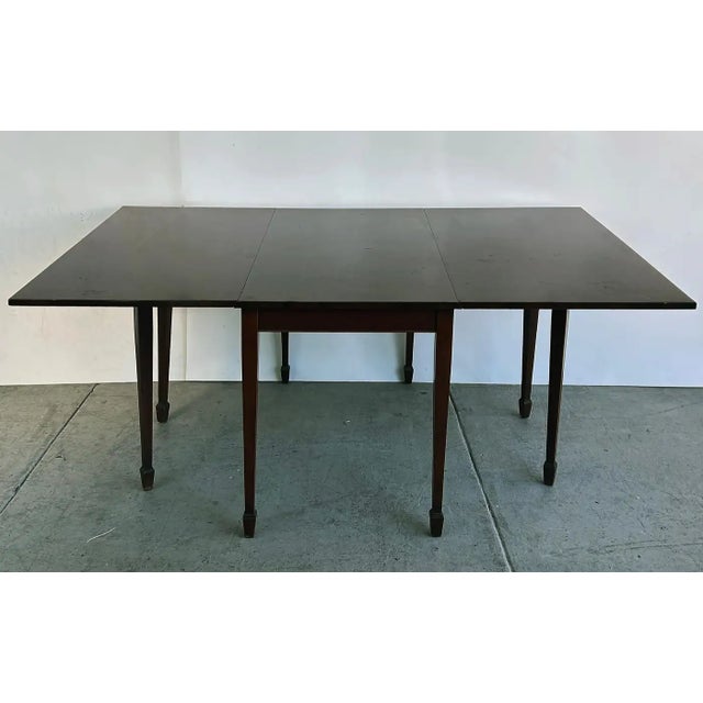 1950s Antique-Style Mahogany Drop-Leaf Gateleg Table Offered for sale is a solid mahogany table with four gatelegs that...