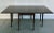 1950s Antique-Style Mahogany Drop-Leaf Gateleg Table Offered for sale is a solid mahogany table with four gatelegs that...