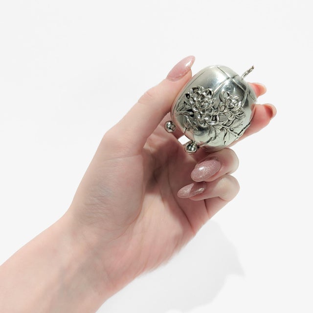 A fine antique Chinese export silver condiment jar. By Luen Wo. In the form of a pumpkin supported by 3 ball feet with a...