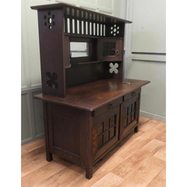 Arts & Crafts Oak Sideboard by Leonard Wyburd for Liberty & Co. This piece is being offered from a dispersal sale of Arts...