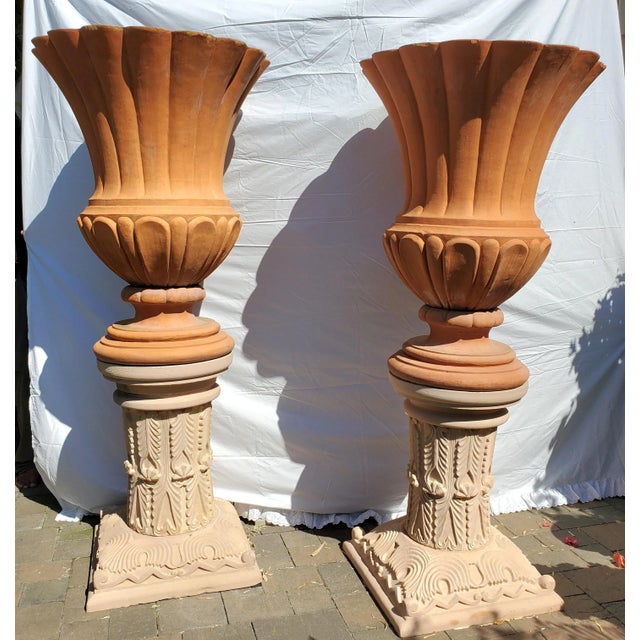A stunning pair of large Italian "Ref Impruneta" terracotta fluted urns featuring scallop edges and reeded bodies. This...