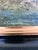 This original vintage oil painting from around the 1960s shows a landscape with tall trees in the foreground and hills and...