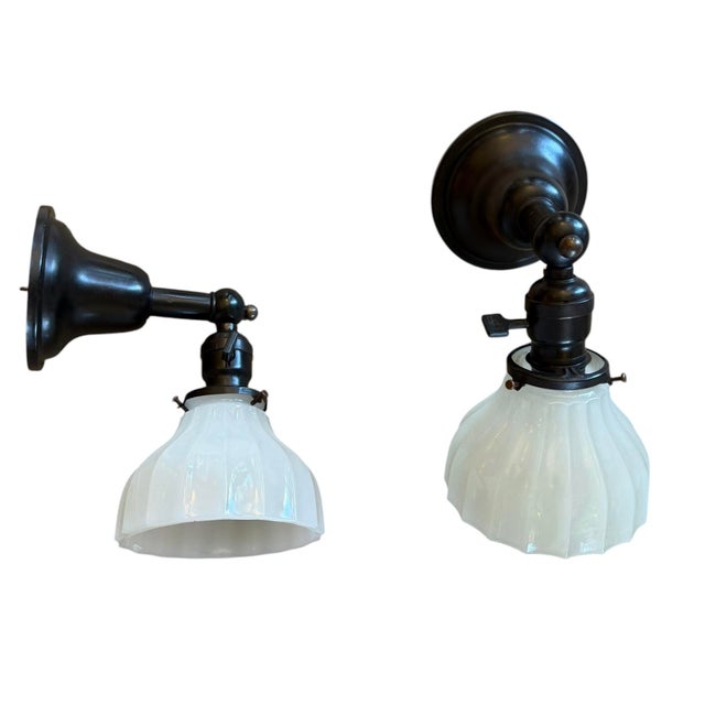 These antique wall sconces feature a distinctive fluted clam broth glass shade. "Clam broth" refers to a semi-opaque,...
