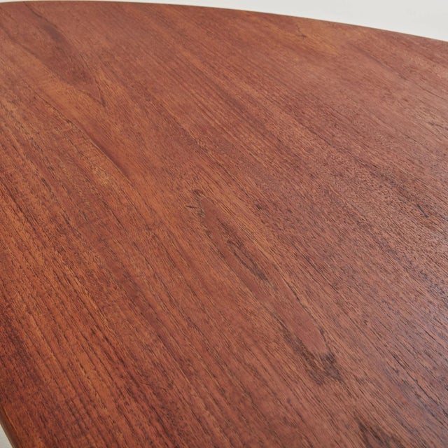 A Danish Modern organic form wood coffee table from the Mid 20th Century featuring a rounded triangular surface and three...