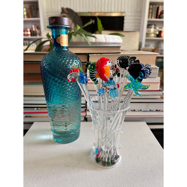 A large collected set of 16 hand-blown glass cocktail stirrers featuring a colorful underwater assortment of tropical...