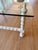 Vintage white lacquer faux bamboo - let table features a square glass and classic spindle-turned spool framing.