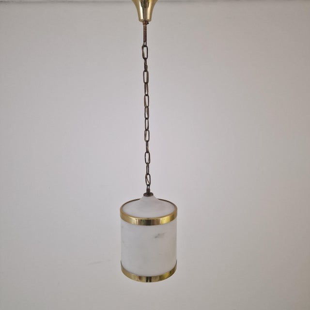 An elegant Mid-Century Modern pendant light made in Italy, beautifully combining clean geometric forms with sophisticated...