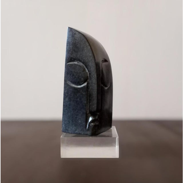 Hand-carved Zimbabwean Shona stone sculpture by artist Luke Office. Executed in dense, dark springstone—a hard variety of...